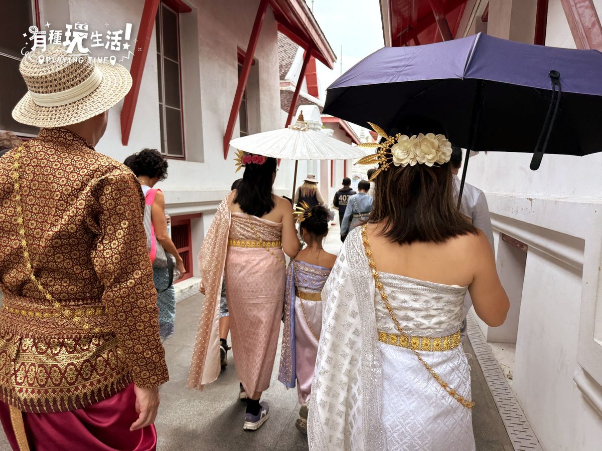 一家人穿泰服撐傘走在鄭王廟旁的背影